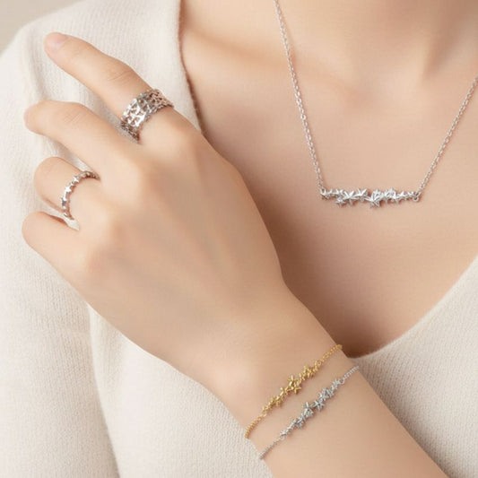 A diverse collection of fashion jewelry from JR Fashion Accessories, featuring silver and gold rings, bracelets, and necklaces with star and floral designs.