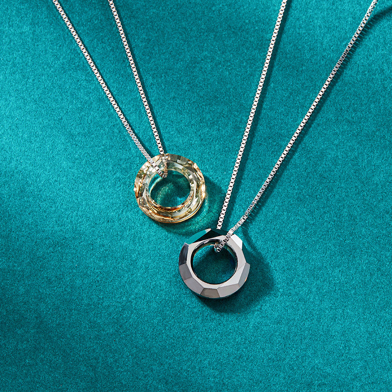A promotional shot of two crystal circle ring pendant necklaces, part of a set of five, made from 925 sterling silver with a box chain.