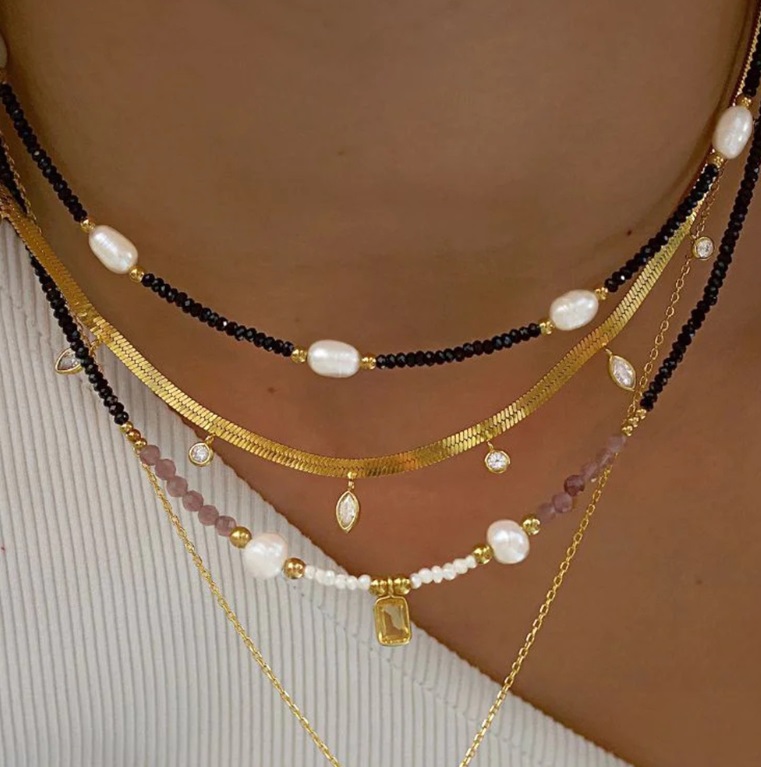 A close-up view of a model wearing the elegant gold-plated stainless steel beaded necklace, showcasing its layered design and fine details.