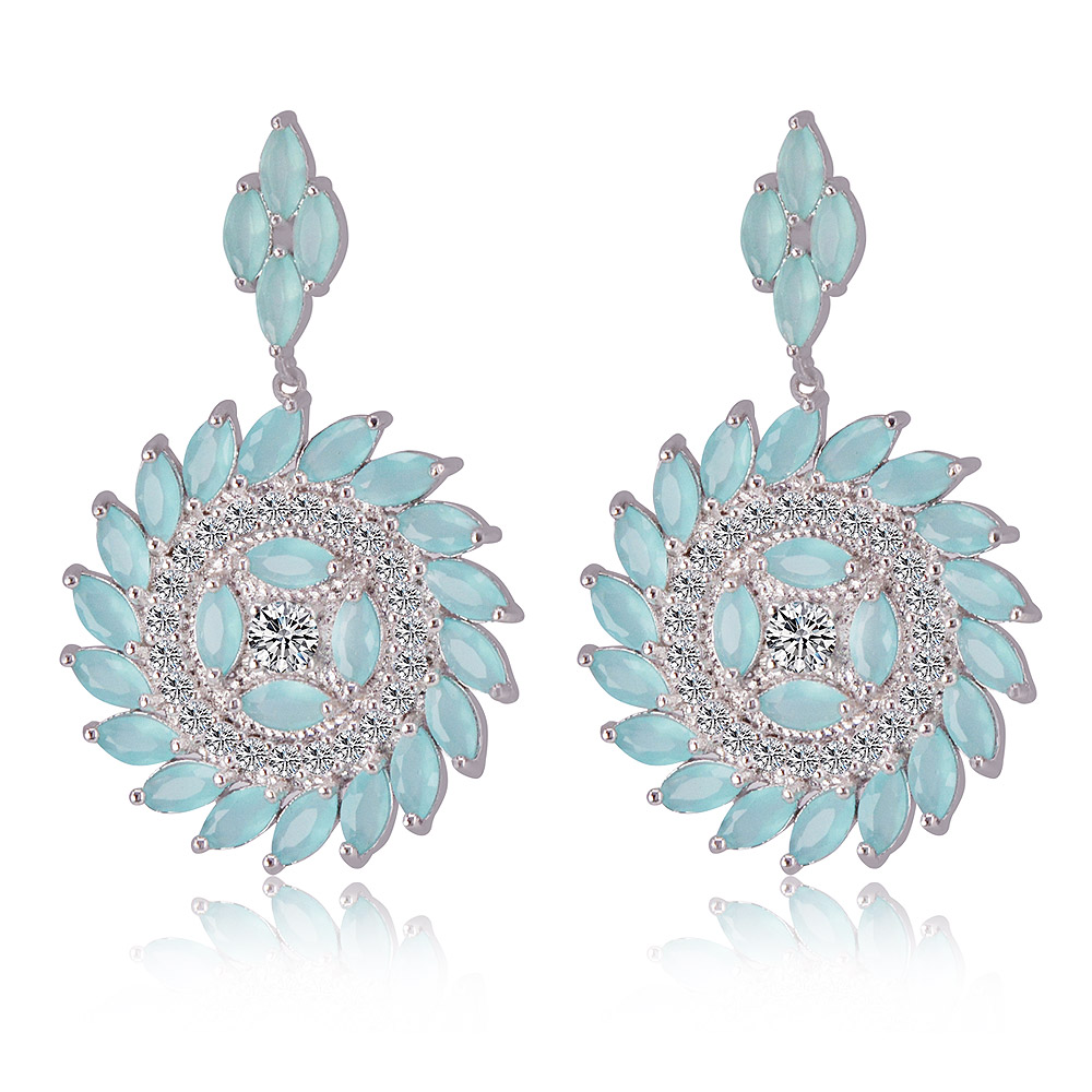 A pair of Blue Rounded Radiant CZ Earrings with a circular, flower-like design. The silver-plated brass earrings feature light blue aquamarine glass and clear cubic zirconia stones.