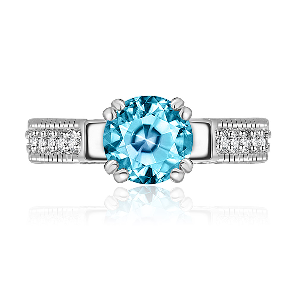 Front view of the Aquamarine Solitaire Ring, featuring a large light blue center stone in a 4-claw setting on a rhodium-plated brass band accented with small clear stones.