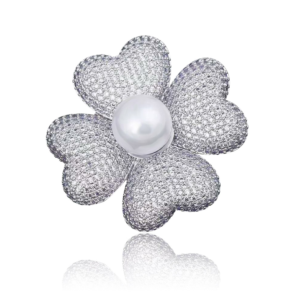 A close-up of the Rhinestone Cloverleaf Brooch, showcasing its four sparkling cubic zirconia petals, central white pearl, and polished rhodium-plated brass finish.