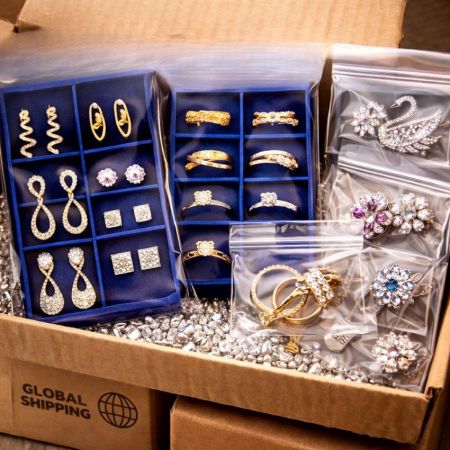 Boîte d'expédition B2B en carton étiquetée 'Expédition mondiale' contenant plusieurs présentoirs en velours et articles emballés pour une logistique de bijoux en gros sécurisée à l'international.