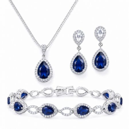 B2B wholesale silver jewelry set with blue pear-shaped cubic zirconia halo necklace, earrings, and bracelet.