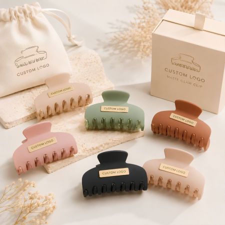 Matte plastic hair claw clips in earth tone shades with customized branding metal plaques for boutique owners.