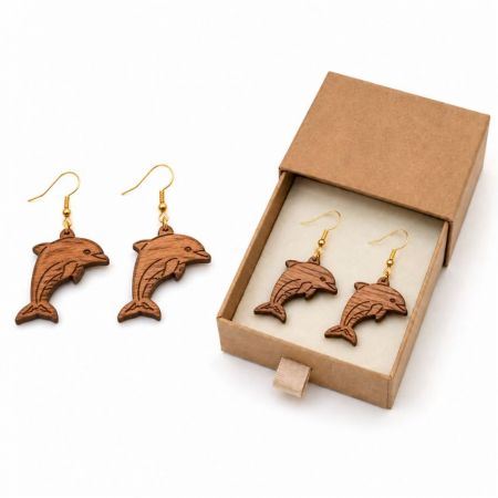Laser-cut dolphin wooden drop earrings shown with biodegradable kraft paper slide box for wholesale distributor.