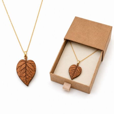 Engraved leaf wooden pendant necklace on gold chain with sustainable kraft slide box for eco-friendly jewelry wholesale.