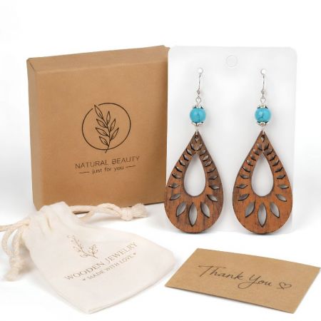 Teardrop cutout wood earrings featuring turquoise beads, with eco-friendly canvas pouch and packaging box.