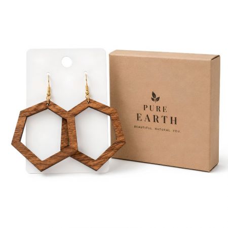 Statement hollow hexagon wooden earrings on a white display card next to a branded kraft paper gift box.