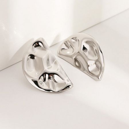 A pair of silver stainless steel half-circle stud earrings with a detailed hammered texture.