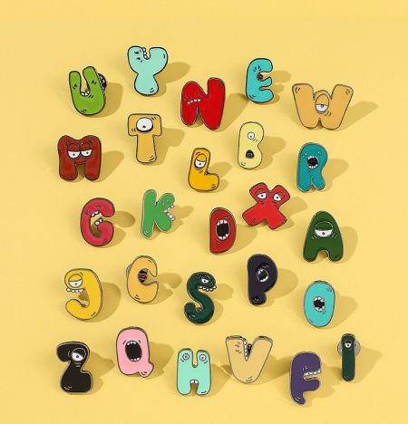 A set of alphabet pins with cute cartoon faces, showcasing the variety of designs available.