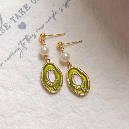 Detailed shot of the avocado-shaped tulip flower earrings with elegant pearl accents.
