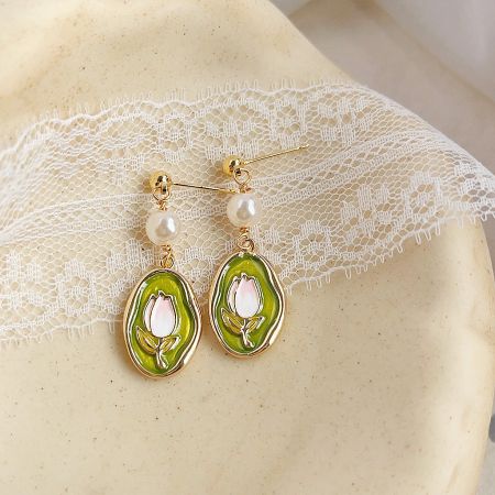 A pair of 14k gold-plated brass earrings featuring a unique avocado and tulip design with enamel.