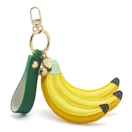 The banana keychain displayed with additional decorative charms, highlighting its versatility as a fashion accessory.