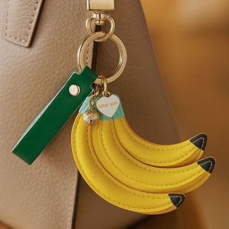 A close-up of the banana keychain showing the gold hardware and a small heart-shaped tag engraved with 'LOVE YOU'.