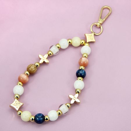 Close-up of the acrylic beaded wrist strap showing gold charms and accents.