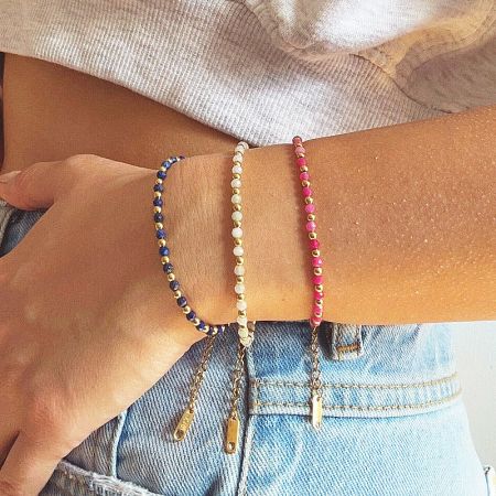 Three beaded bracelets featuring delicate gold charms, displayed together.