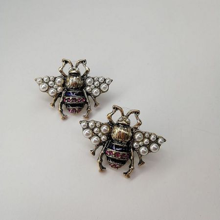 Another angle of the bee-shaped brooches, made of gold and decorated with lustrous pearls and gemstones.