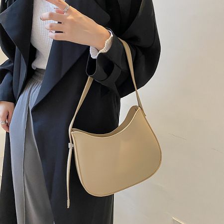 A model wearing a beige version of the PU leather shoulder bag, demonstrating its style.