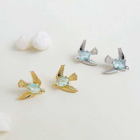 Wholesale Blue Crystal Stone 3D Bird Stud Earrings (5 Pairs) - A pair of gold and silver 3D bird stud earrings with delicate light blue crystal stones, offered by JR Fashion Accessories for wholesale.