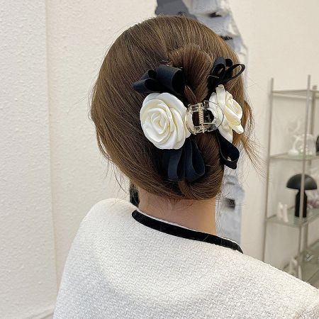 Another view of the camellia hair clips styled in a woman's hair bun.