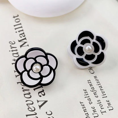 Mini Camellia Flower Acrylic Pearl Hair Clips (Set of 5) - A pair of black and white camellia flower acrylic hair clips with pearl centers, displayed side-by-side to showcase both color options.