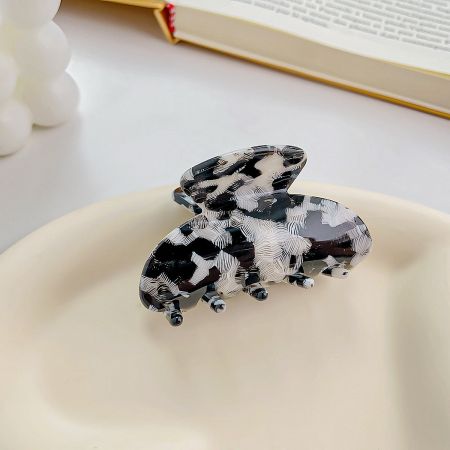 A striking black and white patterned butterfly hair clip.
