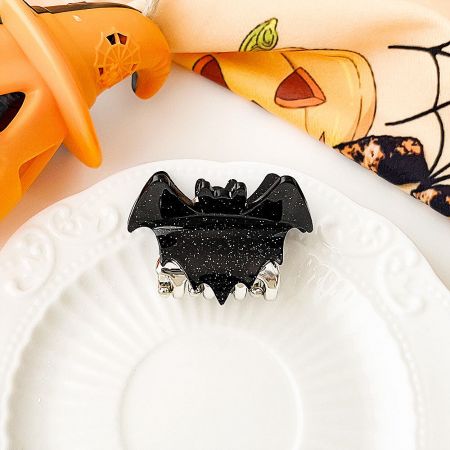 Classic black bat-shaped hair clip with silver glitter details.