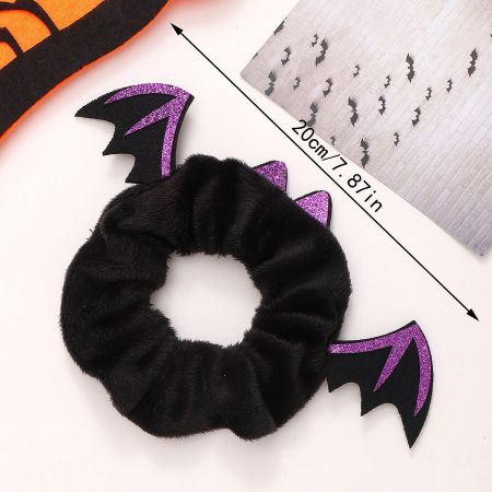 Detailed view of a black and purple fuzzy bat wing scrunchie.