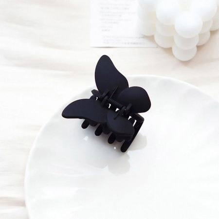 Sleek black butterfly hair clip with a modern matte finish.