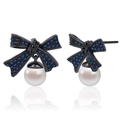 Angled shot of the Blue Bow Pearl Earring, highlighting the sparkle of the blue gemstones and the smooth finish of the pearl.