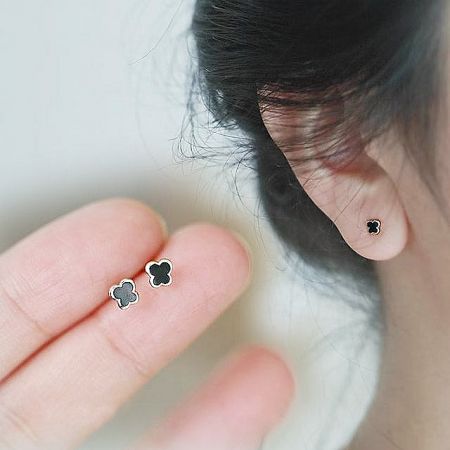 A pair of tiny butterfly stud earrings in 14K gold plate and black enamel.