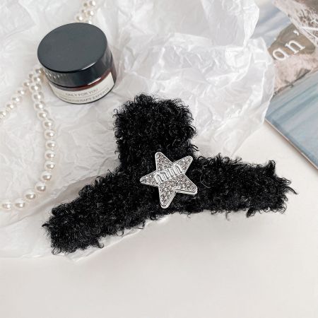 A stylish black plush hair claw clip decorated with a silver star.