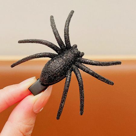 Close-up of a black glittery spider hair clip for Halloween.