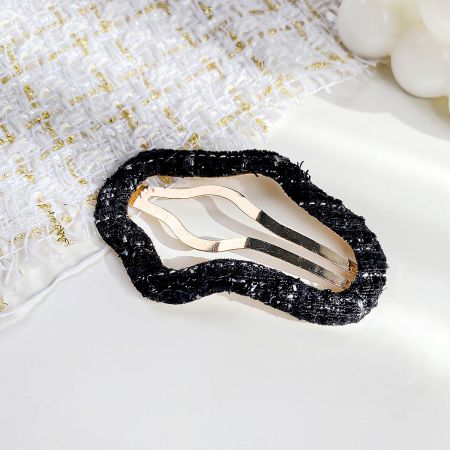 An elegant black and gold beaded hair clip, perfect for special occasions.