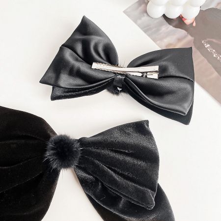 Comparison of a satin and a velvet black hair bow, showcasing different materials.