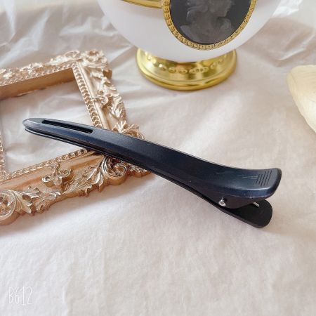 Close-up of a single black salon hairpin side clip.
