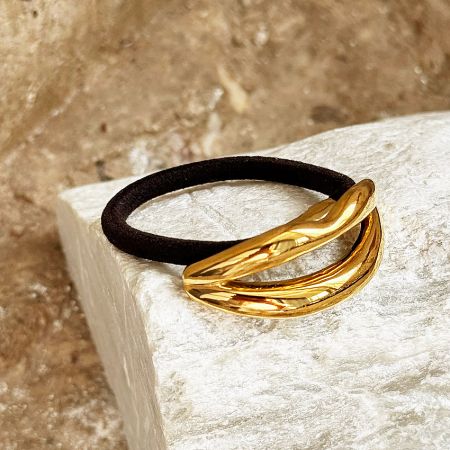 A single black hair tie with the elegant gold lip-shaped accent shown clearly.