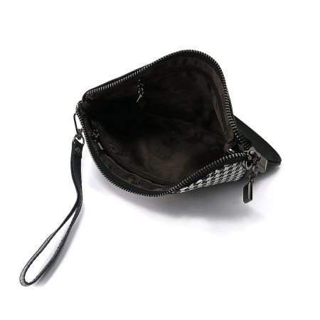 Interior view of the clutch bag showing the zippered pockets.