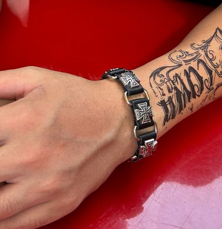 Black PU leather bracelet with cross design worn on a wrist.