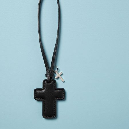 A sleek black leather cross charm featuring a small silver cross accent.