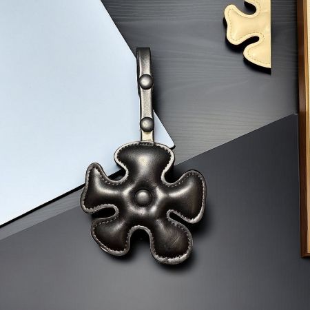 A sleek black leather puzzle piece keychain with a secure metal clasp.