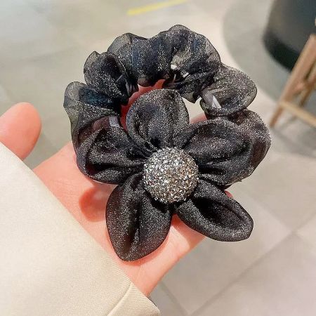 The black organza flower scrunchie shown on a neutral background.