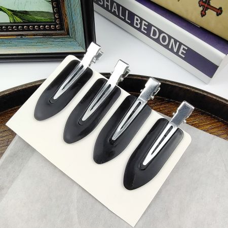 A set of four black creaseless hair clips with silver clasps, ideal for a classic look.