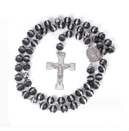 Close-up of the black and silver rosary necklace, showing the detailed crucifix and circular medal.