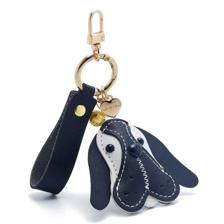 Close-up of the black PU leather dog keychain with gold accessories, showing detailed stitching.