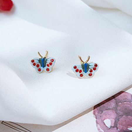 Close-up of a blue and red enamel butterfly earring.