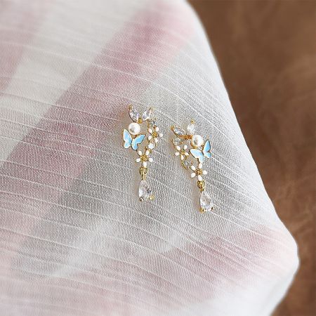 Wholesale 14k Gold Plated Enamel Butterfly and Flower Zircon Pearl Drop Earrings - A pair of 14k gold plated earrings featuring a detailed blue enamel butterfly and white flower, accented with a dangling pearl drop.