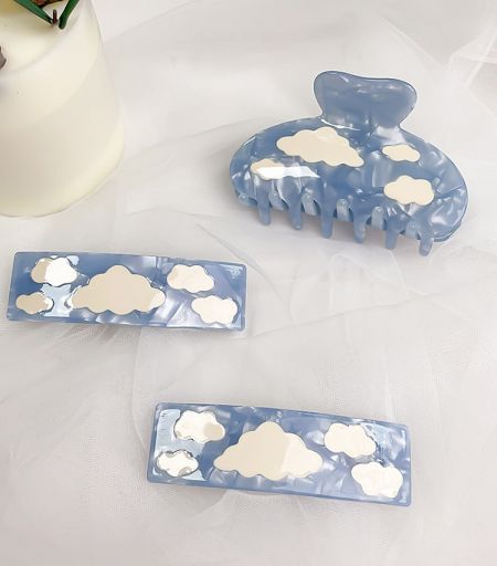 Close-up view of the blue acetate hair clip showcasing the detailed cloud design and glossy finish.