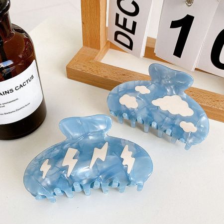 Two blue acetate hair clips, one with a cloud motif and the other with a lightning bolt.